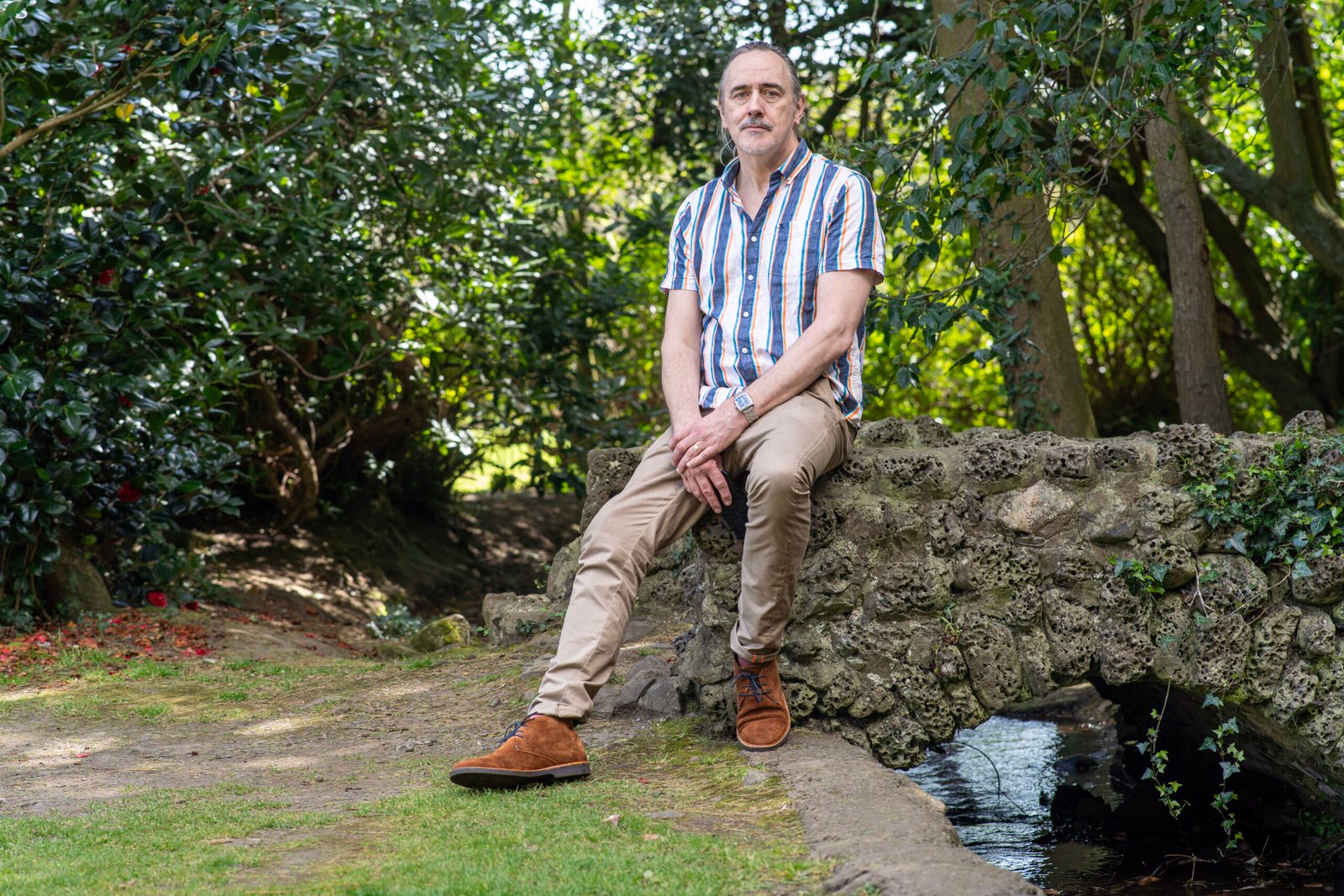 Professional male portrait beside a stone bridge